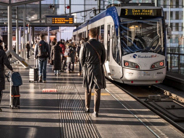 Reizigers die in of uit de tram stappen, op een tramstation in Zuid-Holland